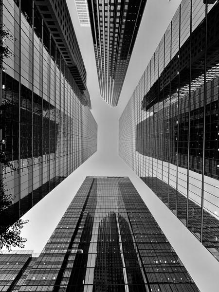 Perspective vertigineuse entre deux tours de verre en noir et blanc