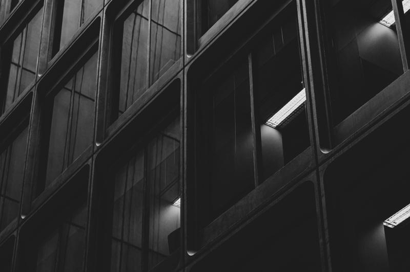 Façade sombre aux lignes obliques ponctuée de lumières