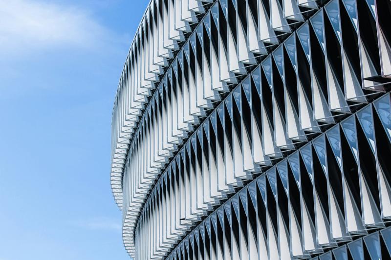 Façade architecturale aux lames obliques sous un ciel bleu