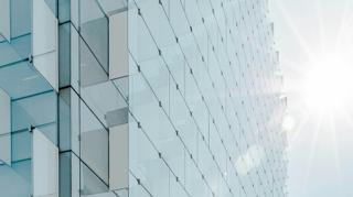 Façade en verre d'un immeuble moderne baignée de lumière